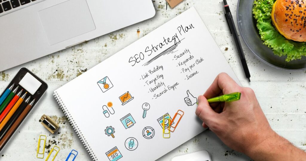 A hand writing out an SEO strategy on paper