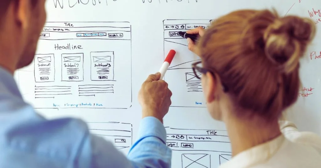 UI UX designers team working on new website wireframe in office.